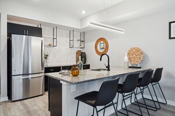 Kitchen with a marble counter top and a stainless steel refrigerator  at The Anchorage on Kelly, Philadelphia